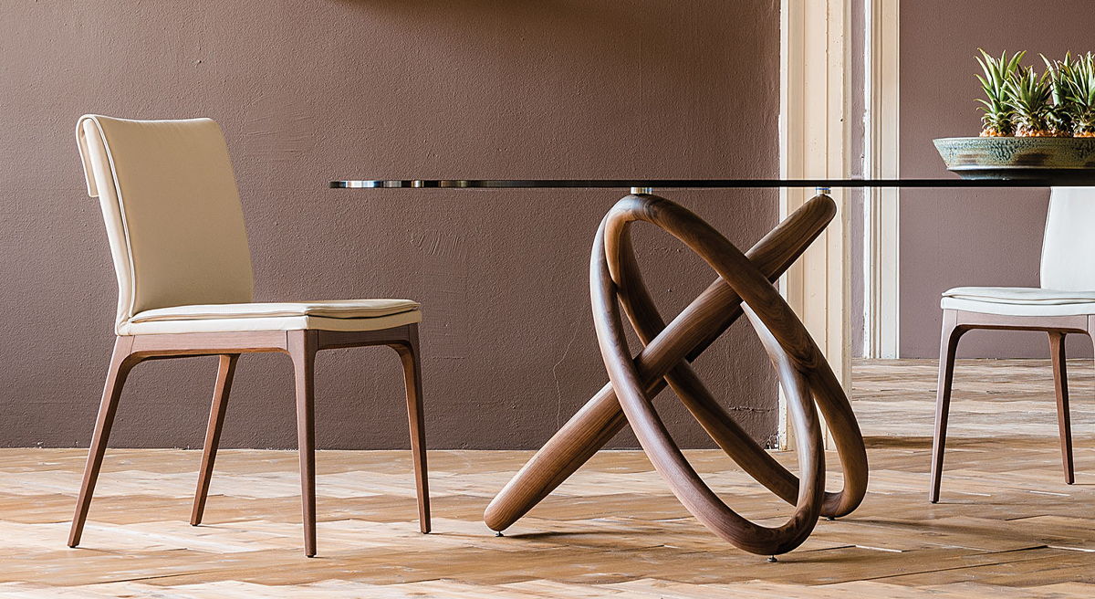 Modern Cattelan Italia dining table with four chairs and decorative items.
