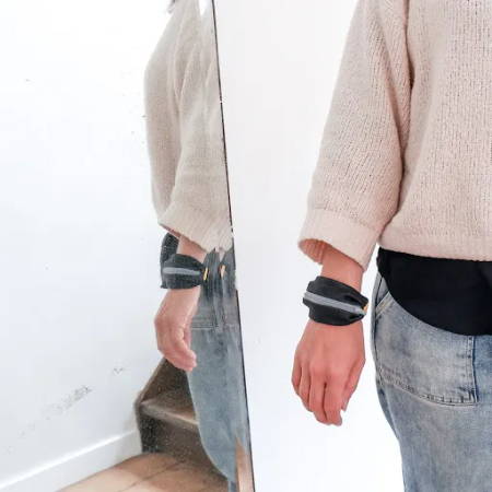 A women wearing a wrist pouch with a zipper made out of denim fabric
