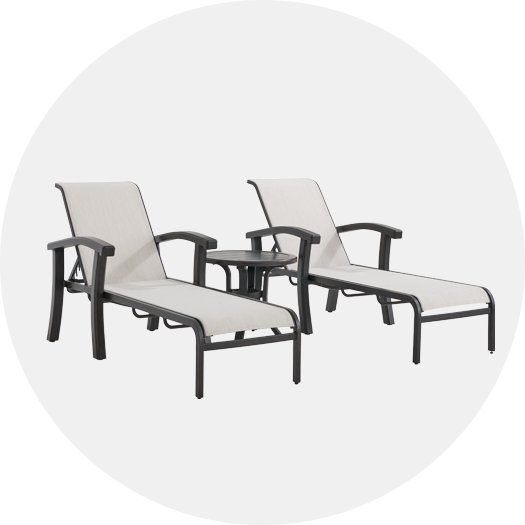 Two lounge chairs with a small table between them.