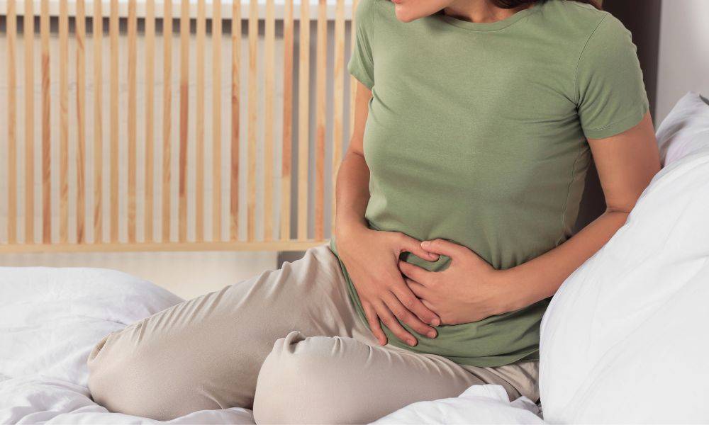Woman with pelvic pain holding her stomach
