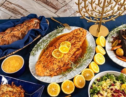 A festive table setting featuring a large fish dish and various side dishes.