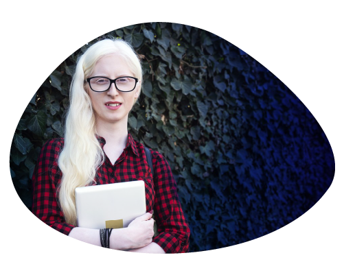 Person with long blonde hair holding a notebook, standing against a dark background.