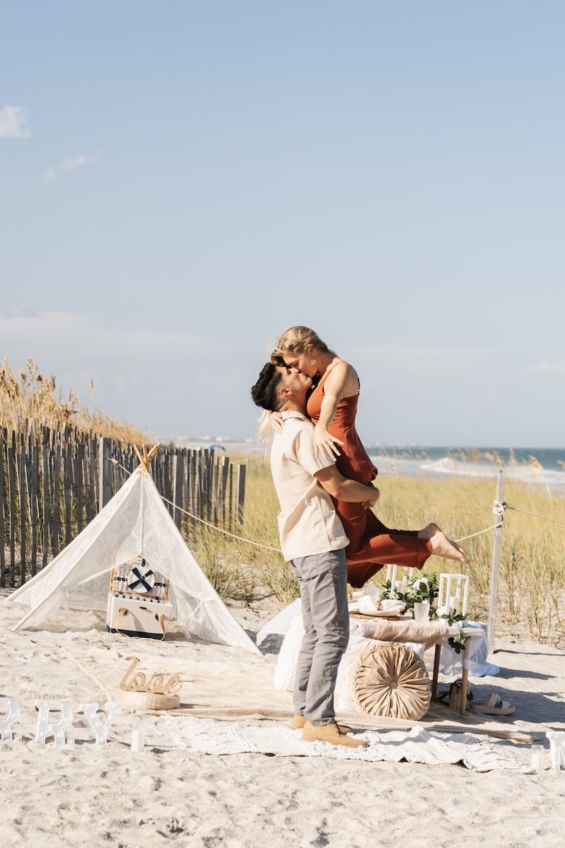 engaged couple kissing on wrightsville beach, nc