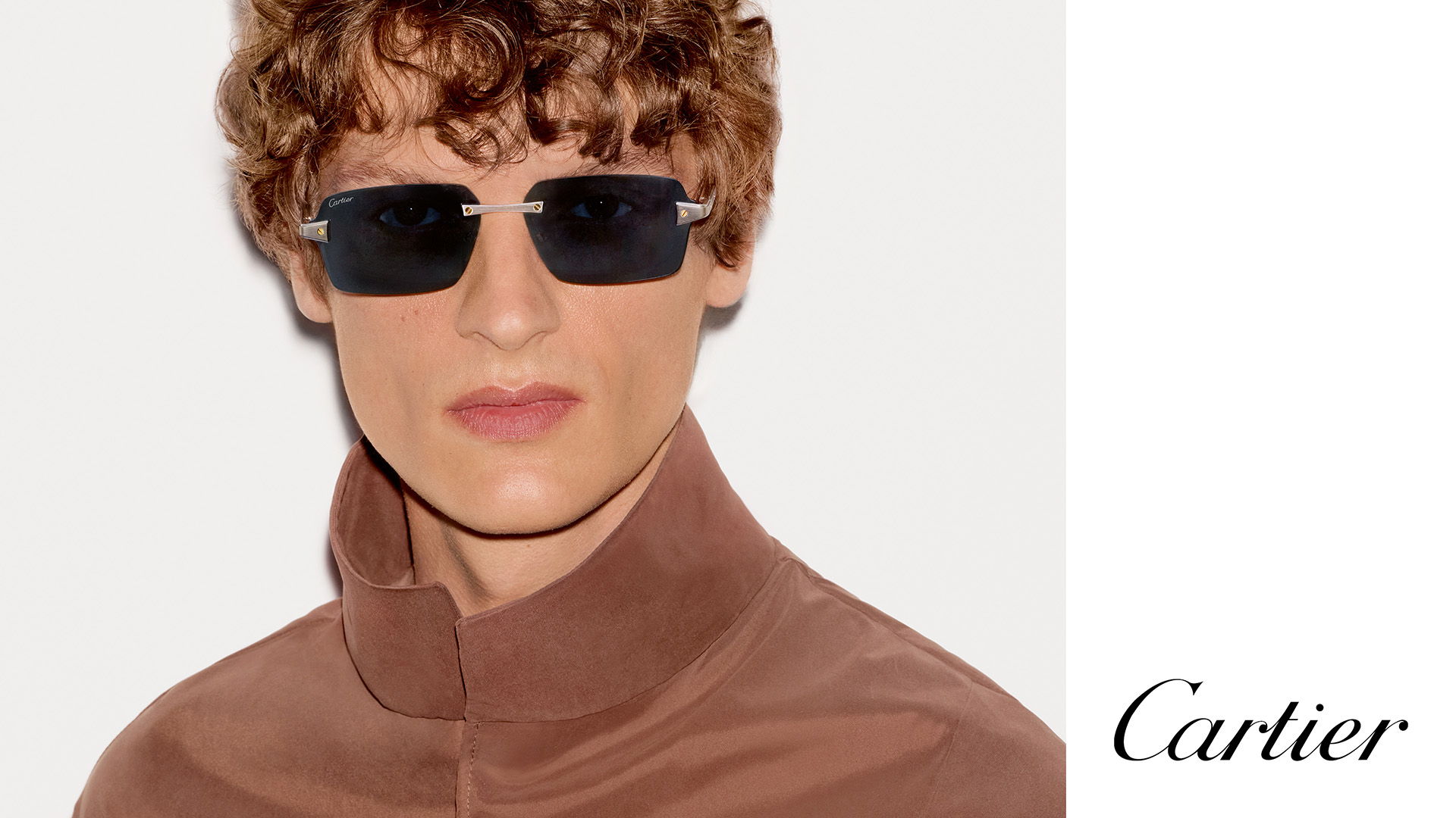 Model wearing Cartier sunglasses with a brown jacket, featuring the Cartier logo.