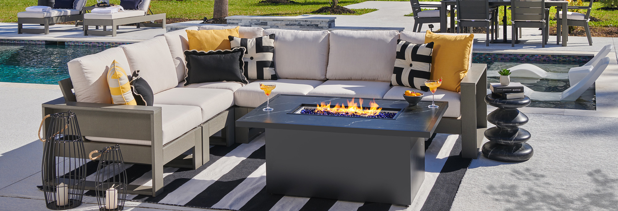 Outdoor seating area with cushions and a fire pit.