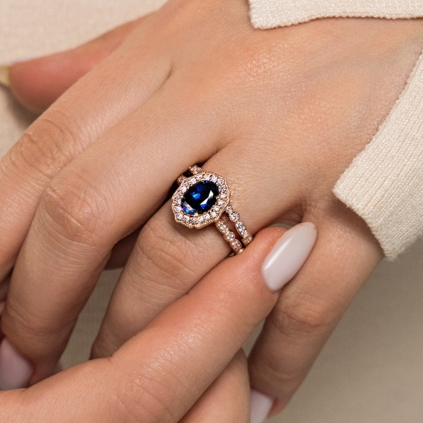 vintage style rose gold engagement ring with diamond halo and oval lab grown blue sapphire center stone