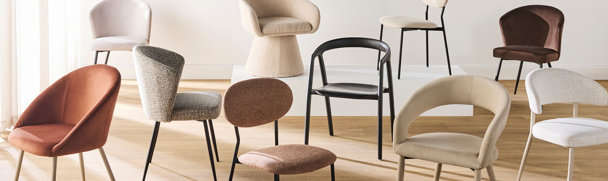 Various stylish chairs arranged in a bright, modern interior setting.