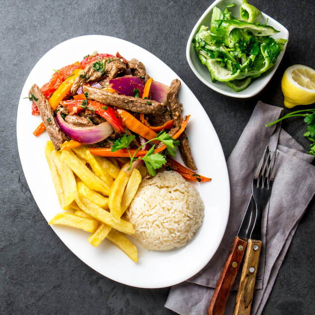 peruvian chinese food - lomo saltado on a plate made of beef stir fry with fries and rice