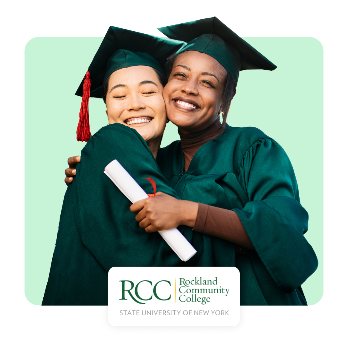 Two graduates in caps and gowns embracing, celebrating their achievement.