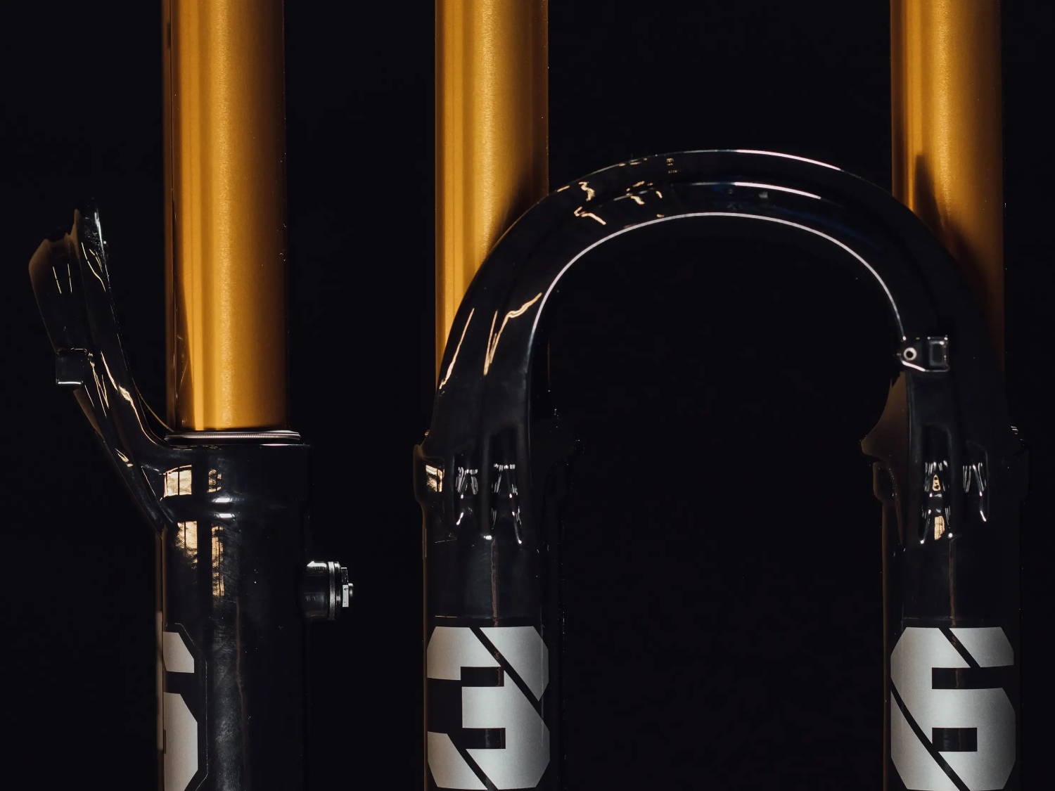 Fox Factory 36 in shiny black on a black background detail of the arch and 36 logos and kashima stanchions