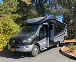 A black and gray RV parked in a residential area.