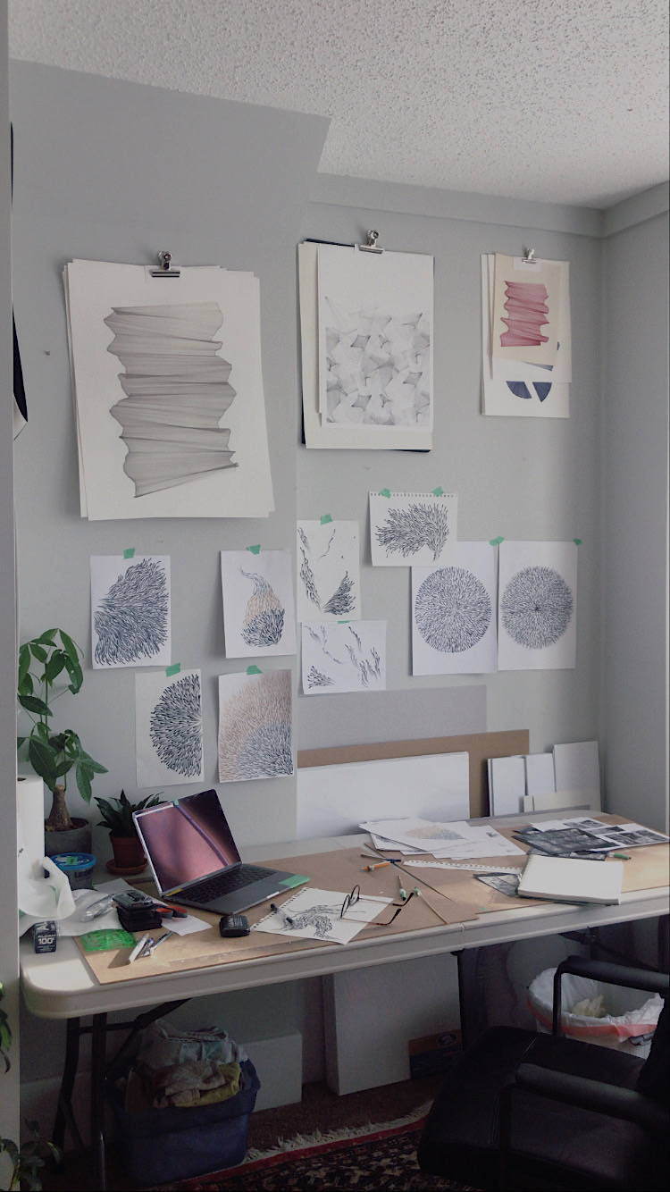 Sketches, works in progress, and inspiration images hang on the wall over Cassie's desk. 
