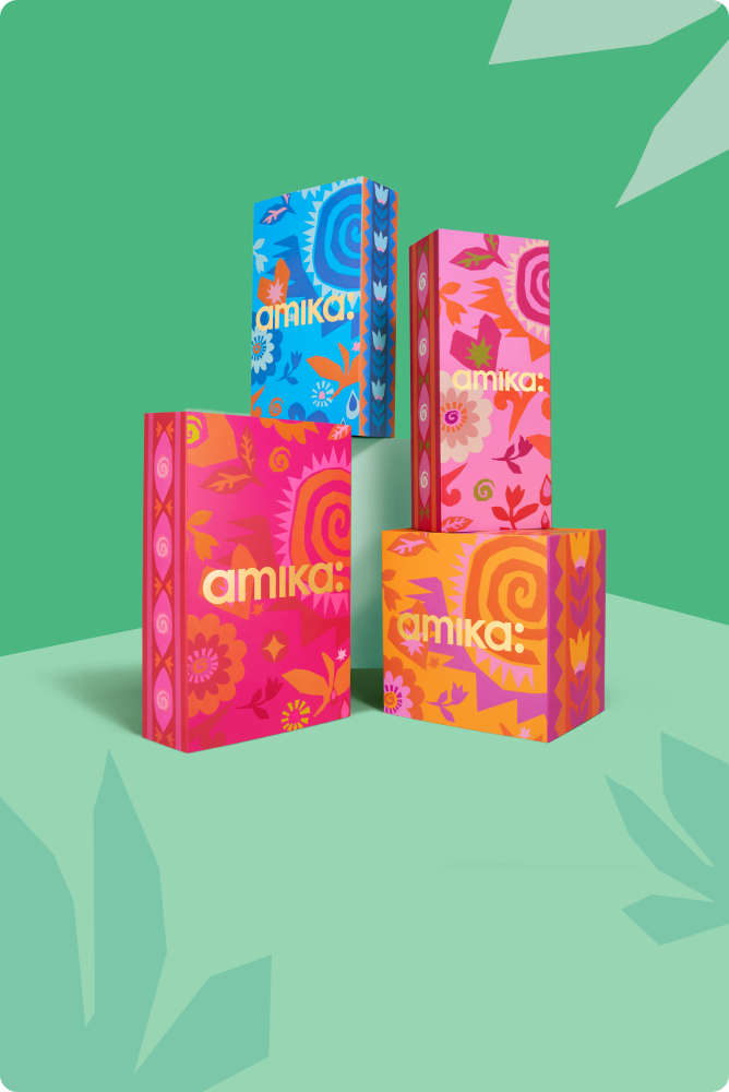 Colorful Amika product boxes on a green background.