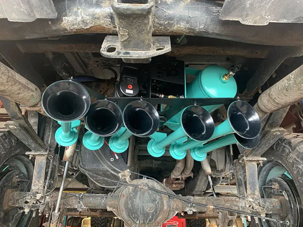Custom teal six-horn train horn kit with air tank mounted under Caitlyn's Silverado photo 3