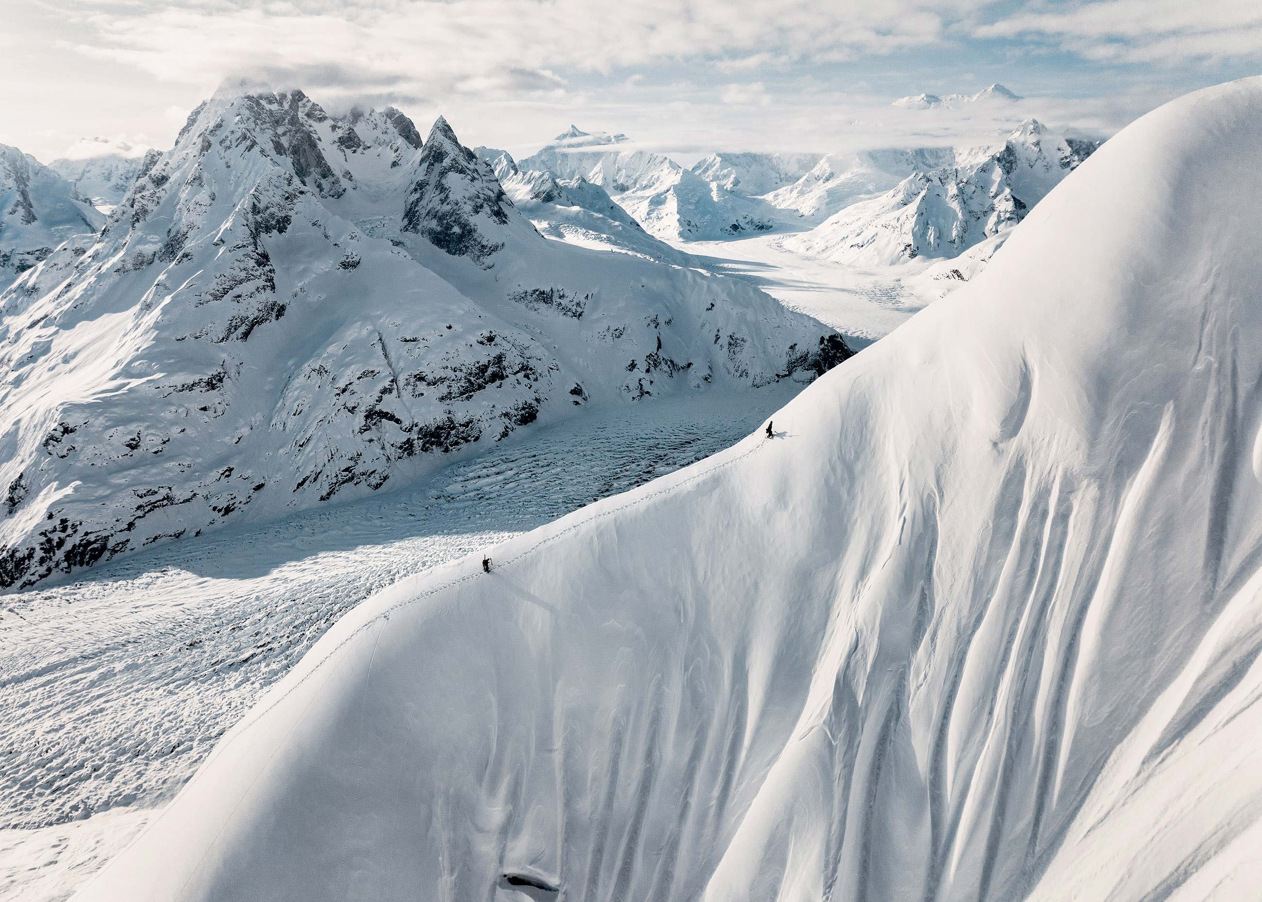 Snow-covered mountains with dramatic slopes and a glacier in the background.