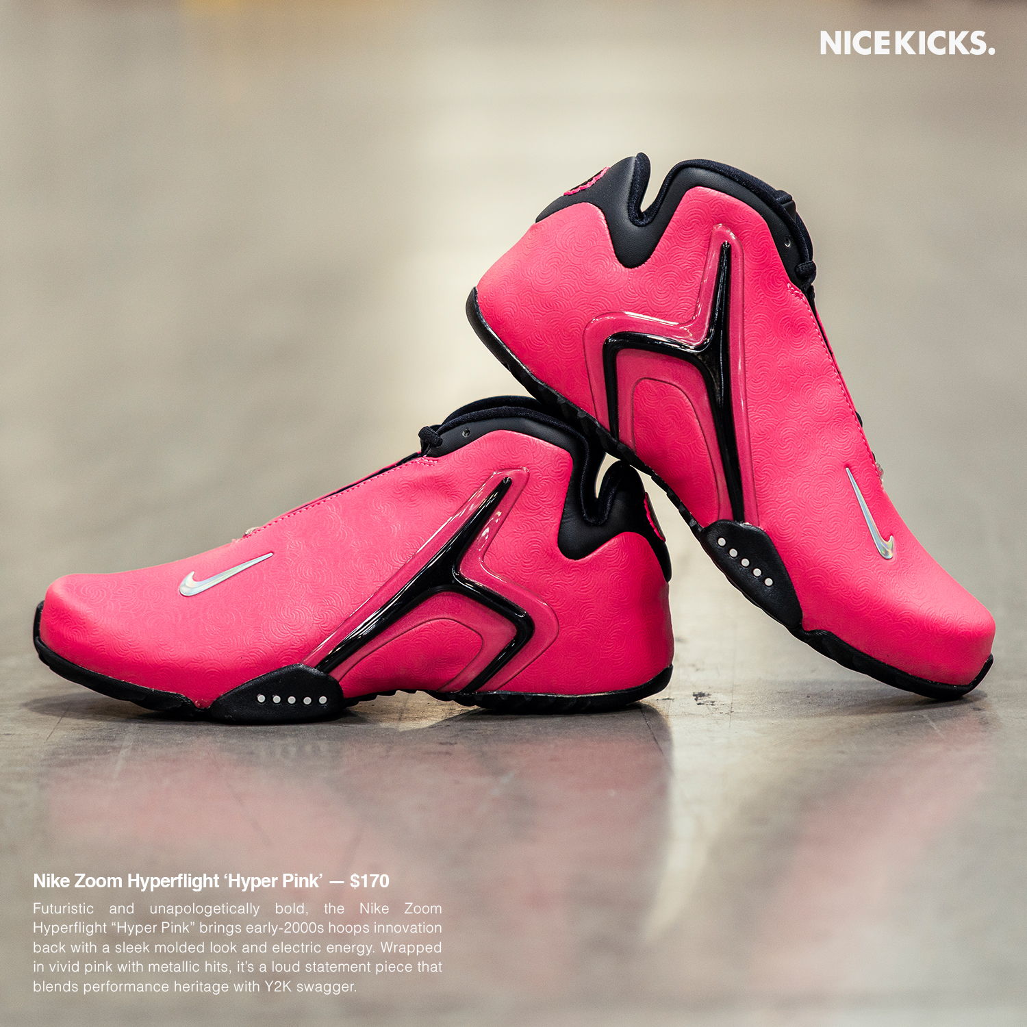 A pair of pink Nike shoes on a gray surface.