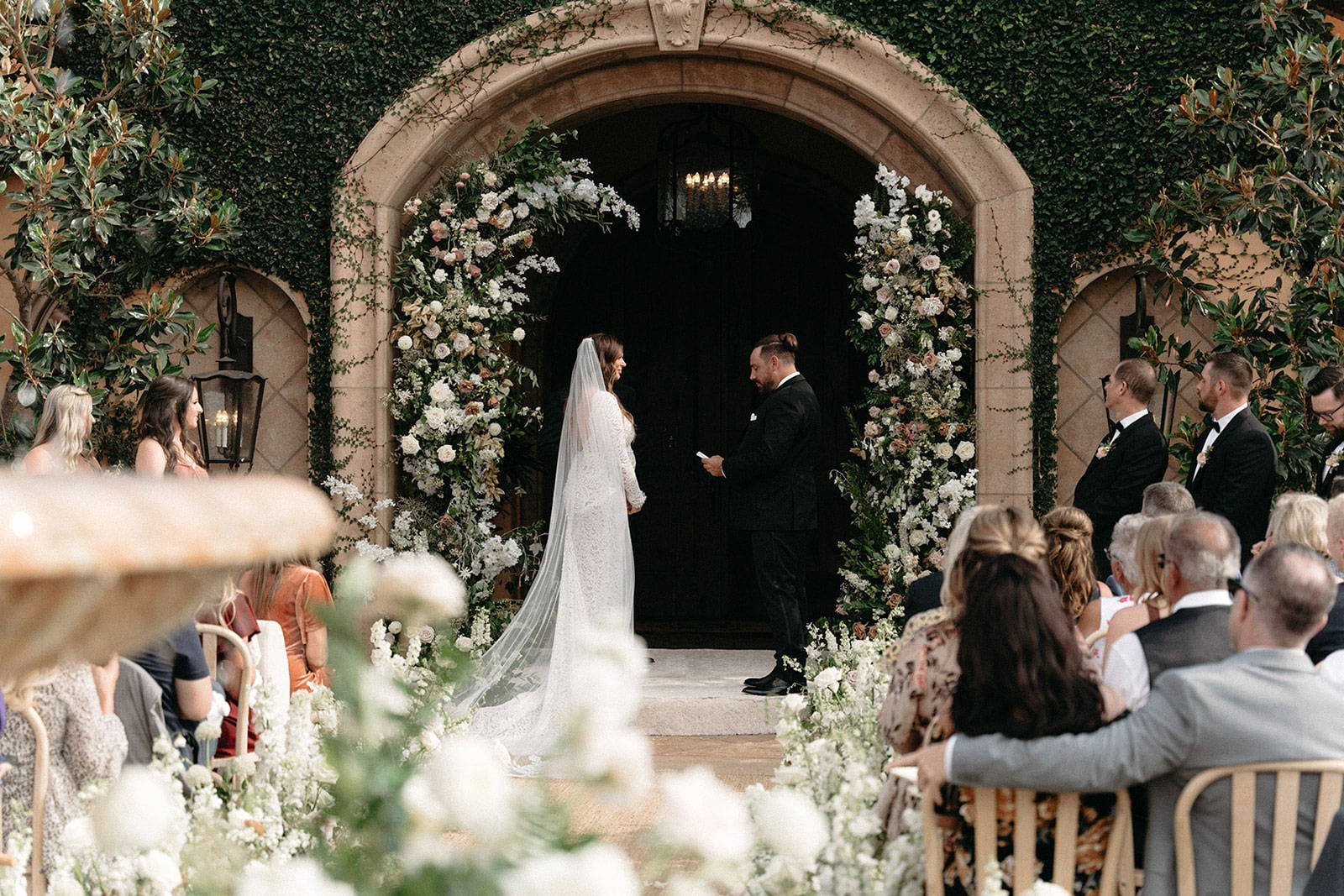 Bride and groom under floral archway