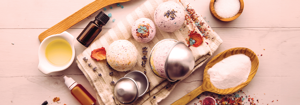 Ingredients and tools for making bath bombs on a wooden surface.