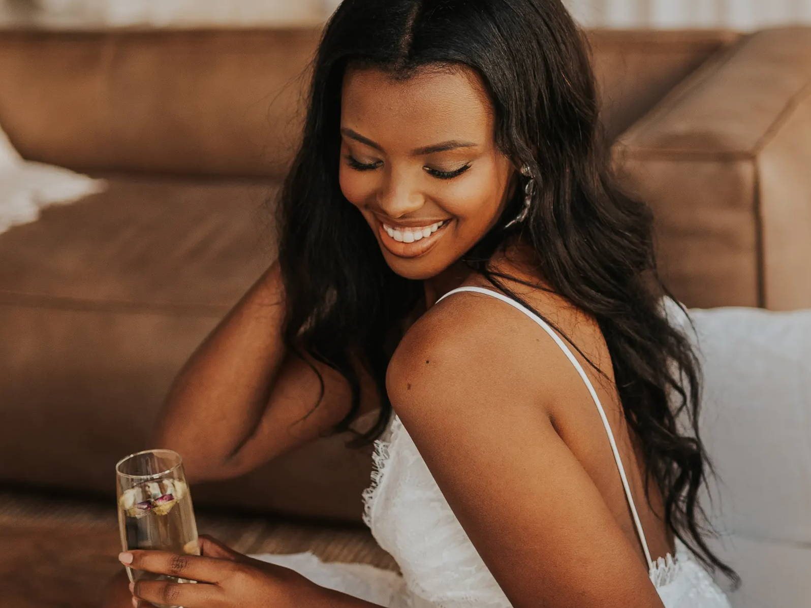 Bride sipping champagne with petals in it