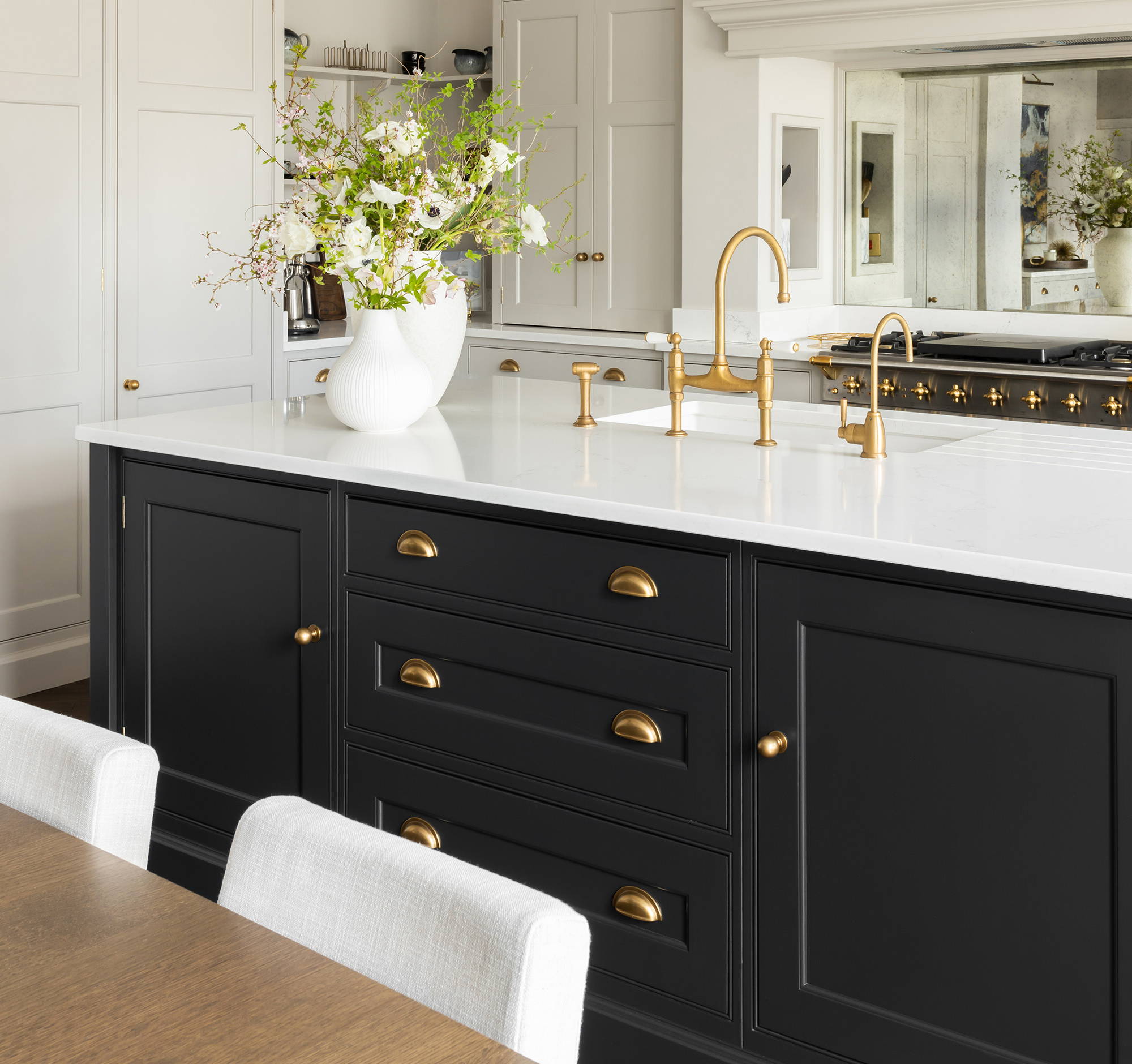 Modern navy and white kitchen designed by Rachel Somerville, complete with brass handles and finishes and neutral decor