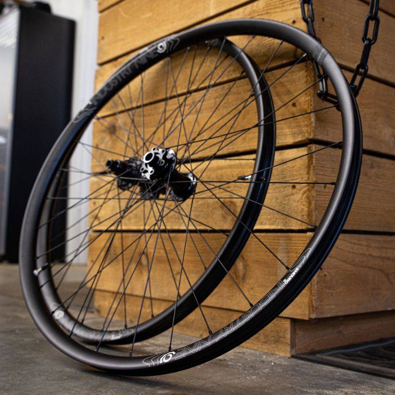 industry nine mountain bike wheels laying against wooden desk