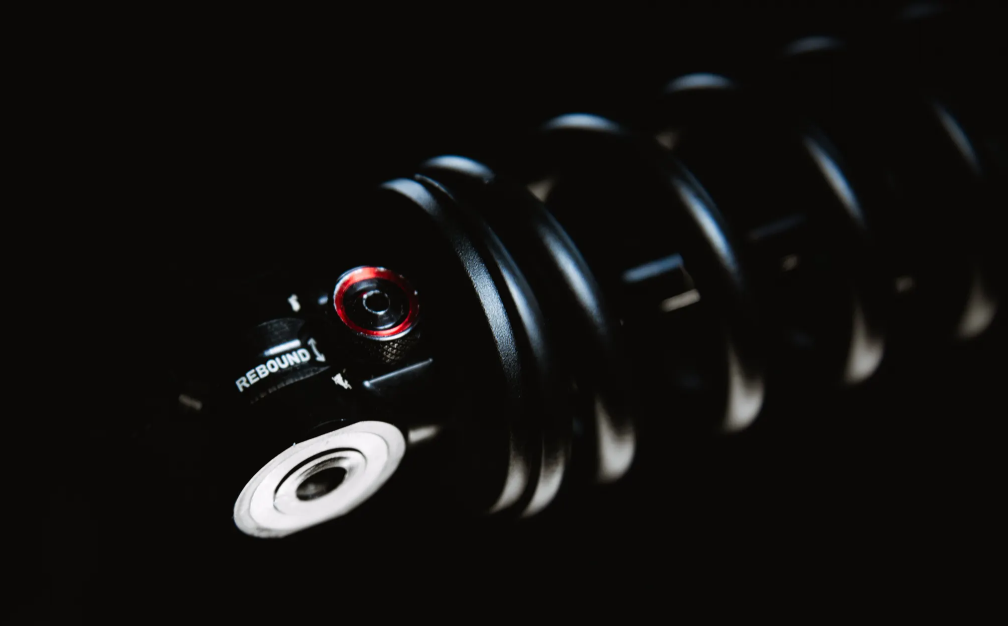 Detail of the rebound adjustment on the rockshox super deluxe ultimate coil on a black background