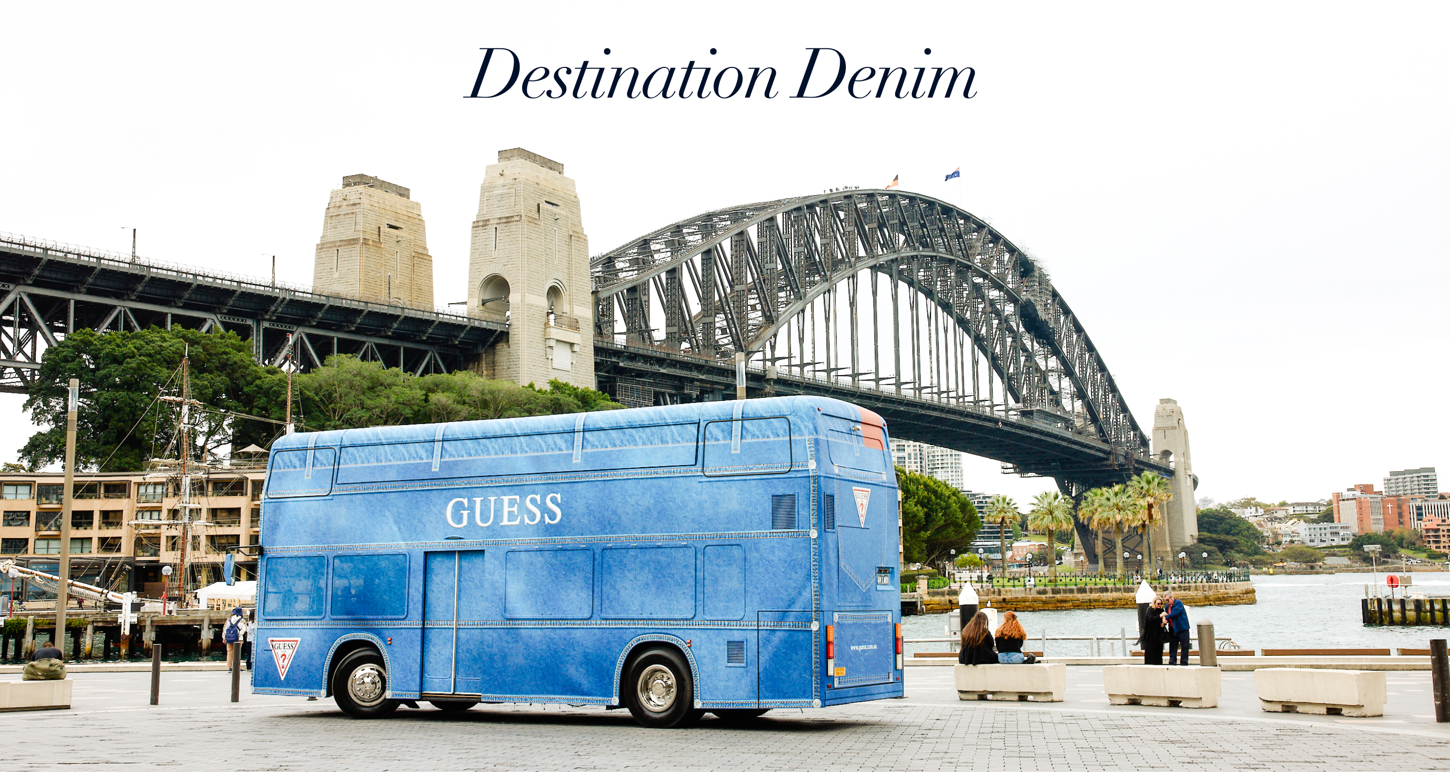 Blue denim GUESS bus near Sydney Harbour Bridge with text 
