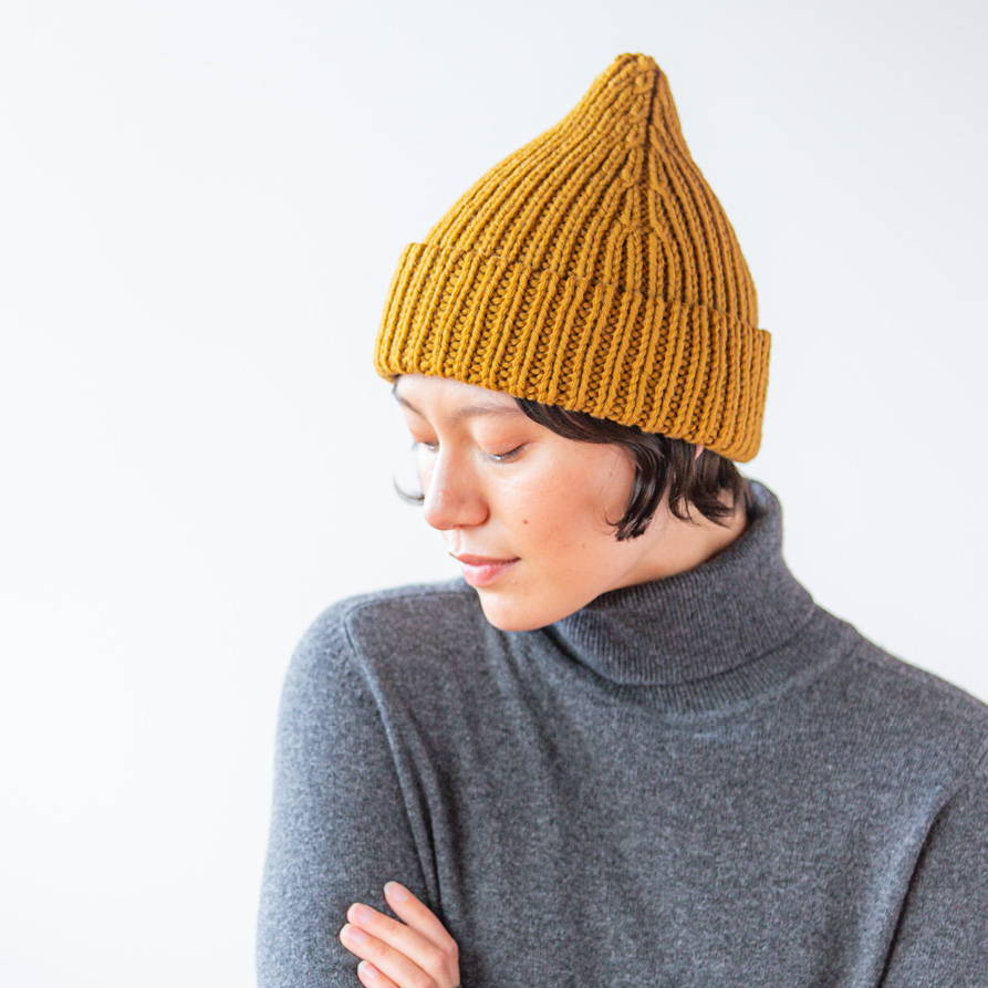 Kaya models a hand knit chunky weight yarn hat.