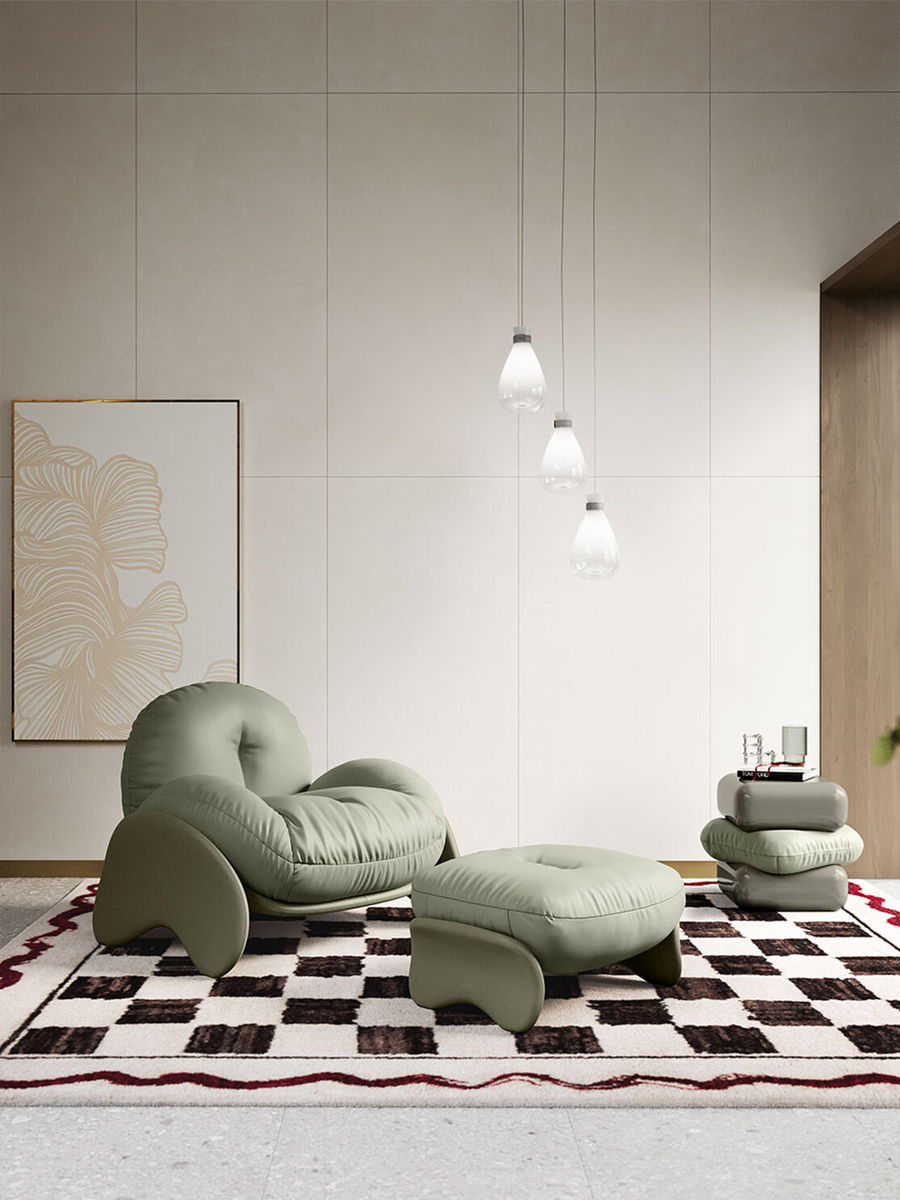 Modern living room with green Squash Lounge Chair by Poltrona Frau on a checkered rug and pendant lights.
