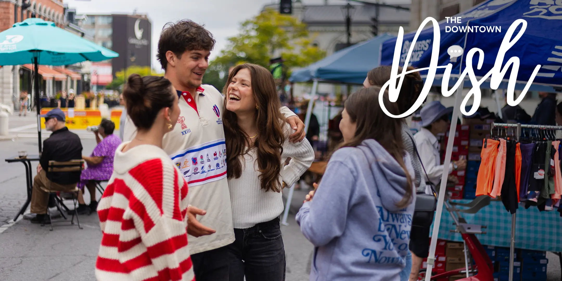 A group of friends laughing together at an outdoor market.