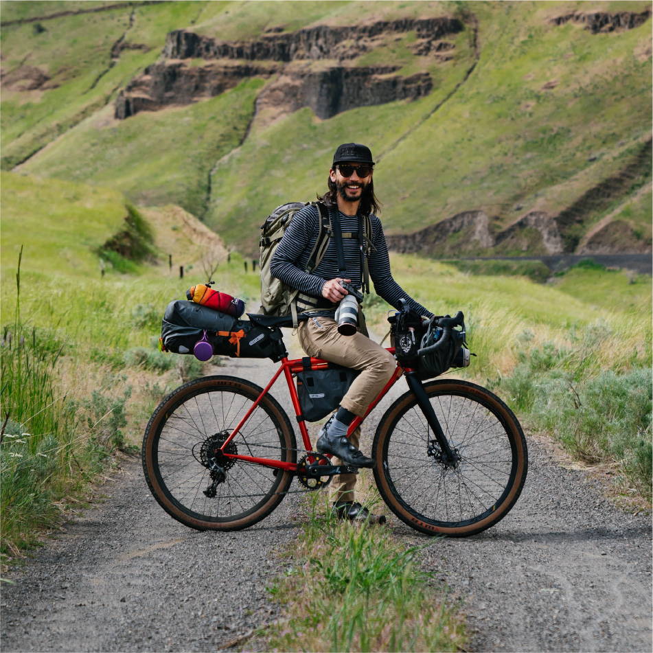 Man with camera on dirt bike in the mountains