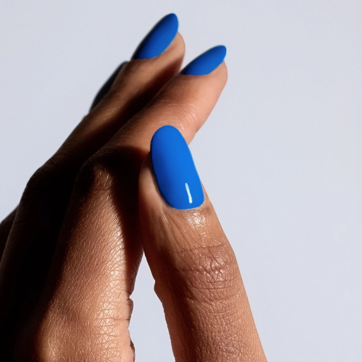 Shade Poolside from Glossify's Endless Summer collection on a deep skin tone.