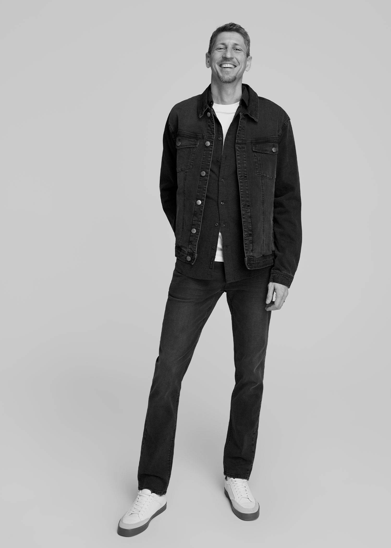Tall man wearing a black denim jacket and jeans
