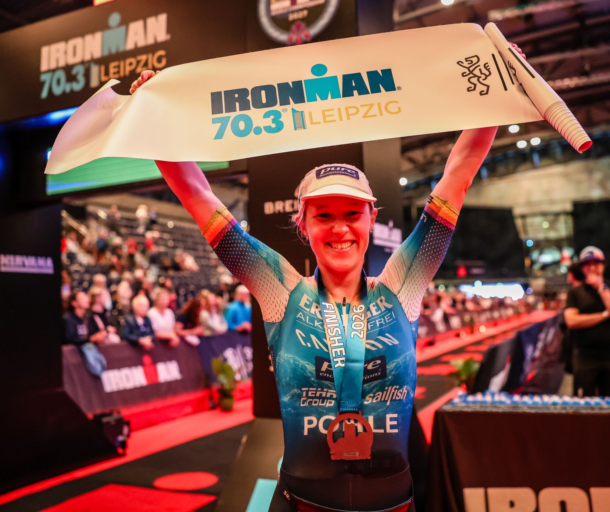 Caroline Pohle strahlt nach ihrem Sieg beim Ironman 70.3 Leipzig in die Kamera.
