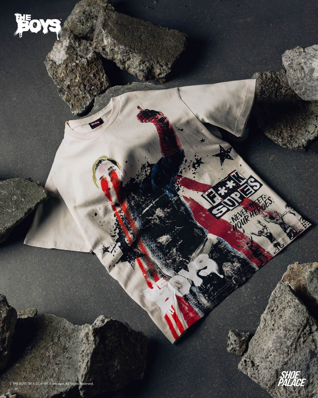 Graphic t-shirt displayed on rocks, featuring bold colors and imagery.