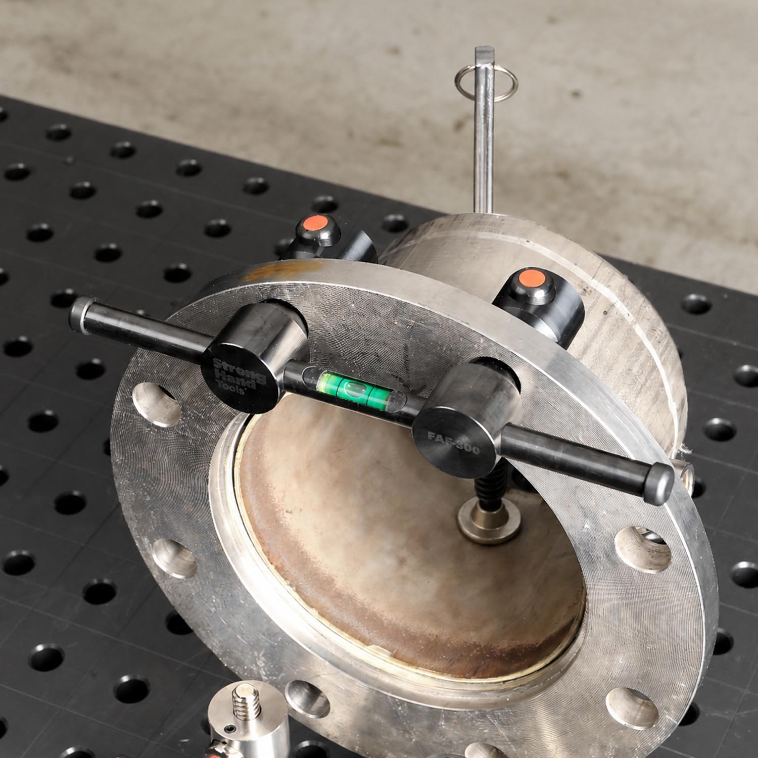 A metallic flange with measuring tools on a work surface.