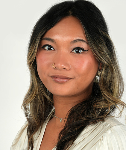 Young woman with long hair, wearing a light-colored top and subtle makeup.