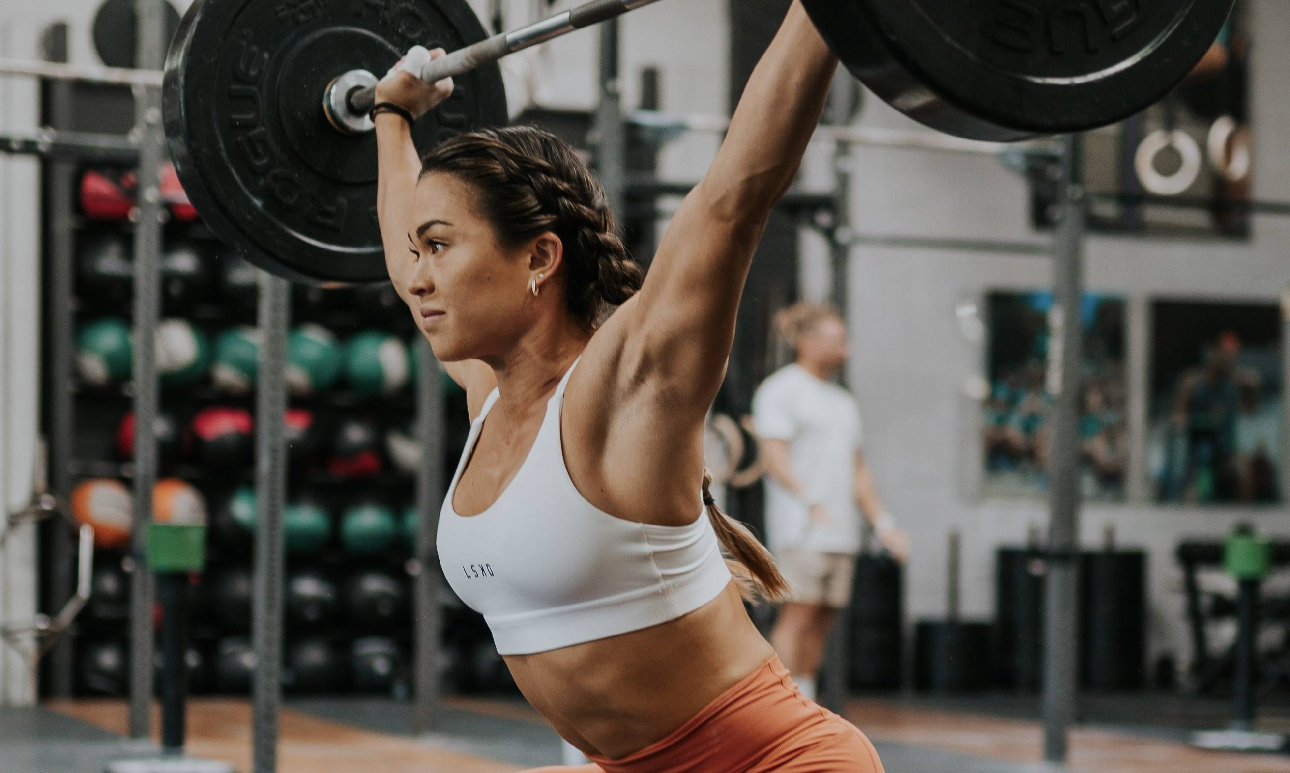 girl lifting a barbell above her head