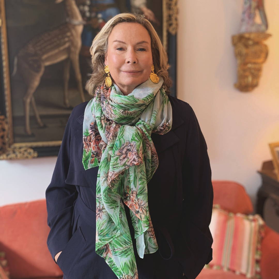 Ala Isham wearing silk green scarf with her jacket at her apartment in New York City