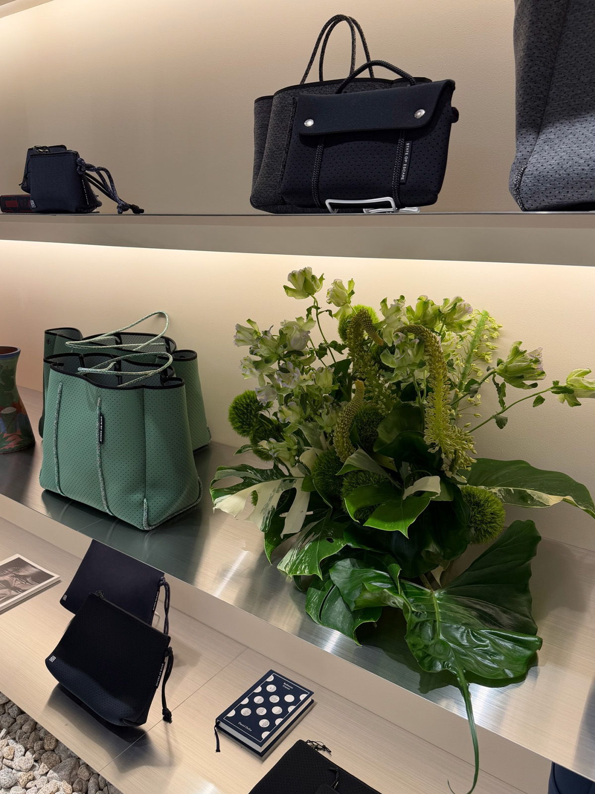 Handbags on display with a floral arrangement and accessories.
