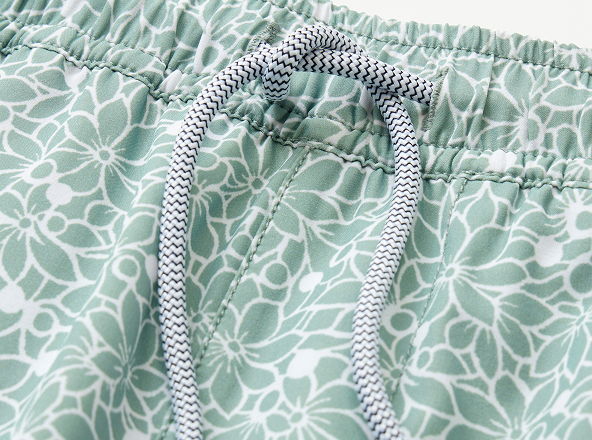 Close-up of patterned swim shorts with drawstring detail.