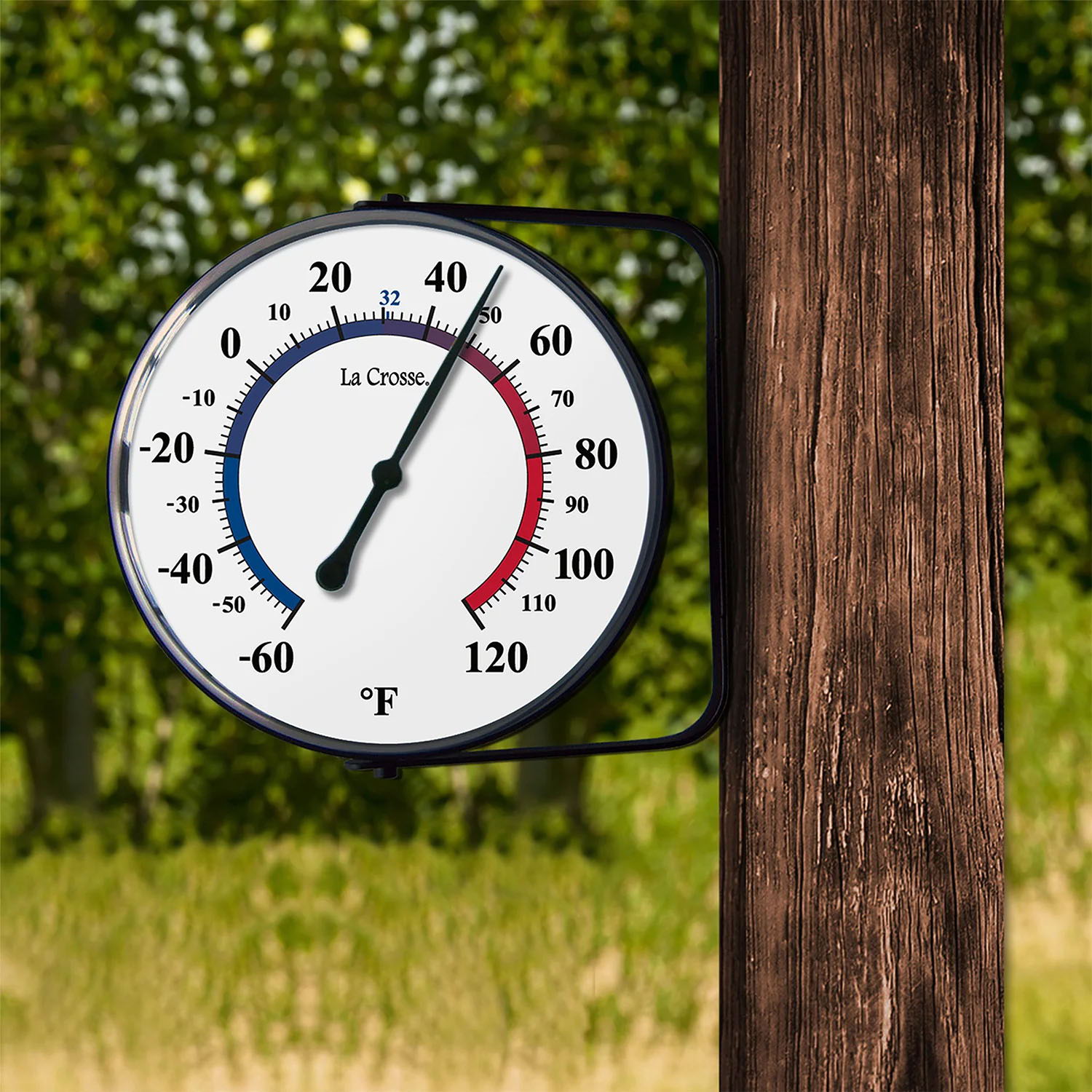 104-105 outdoor thermometer displaying temperature in Fahrenheit on a wooden post.