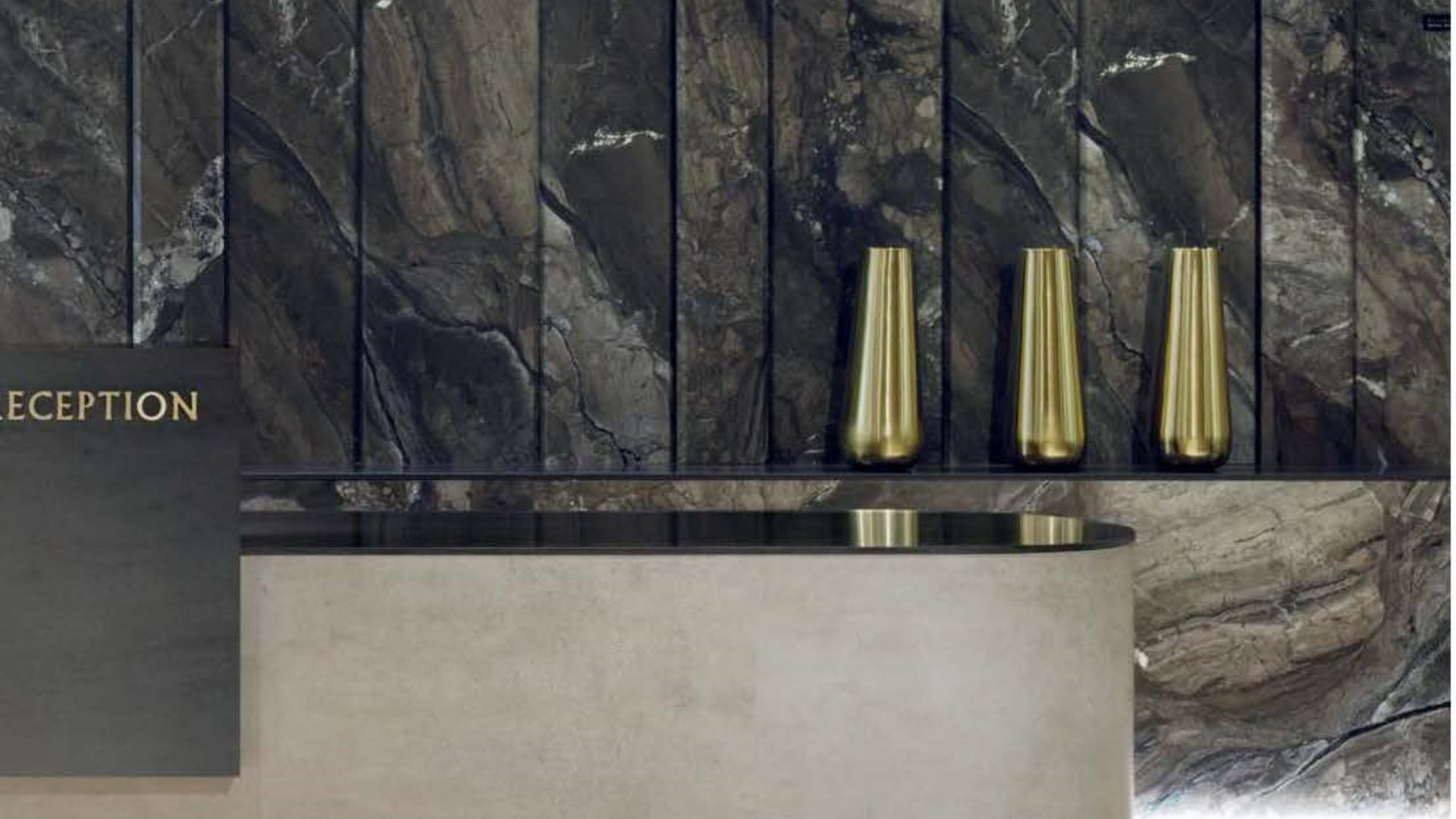Modern reception area with dark Alluslate marble effect wall panels, stone effect Alluslate front reception desk and gold vases.