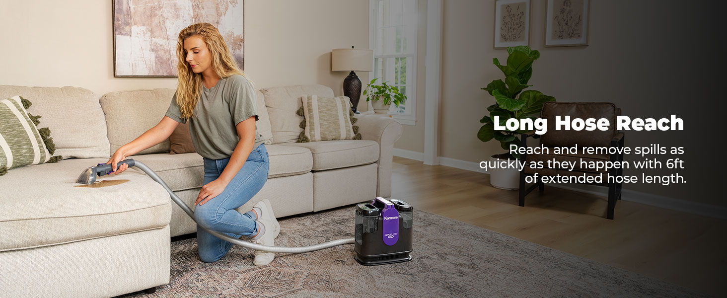Woman cleaning a couch with a spot cleaner. Long hose feature highlighted.