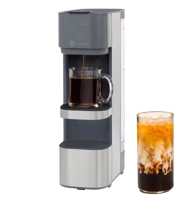 Coffee machine with a glass of iced coffee beside it.