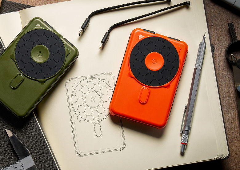 Two colorful devices next to a sketchbook and drawing tools.