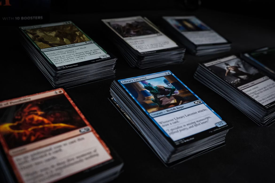mtg double strike A collection of trading cards arranged on a dark surface.