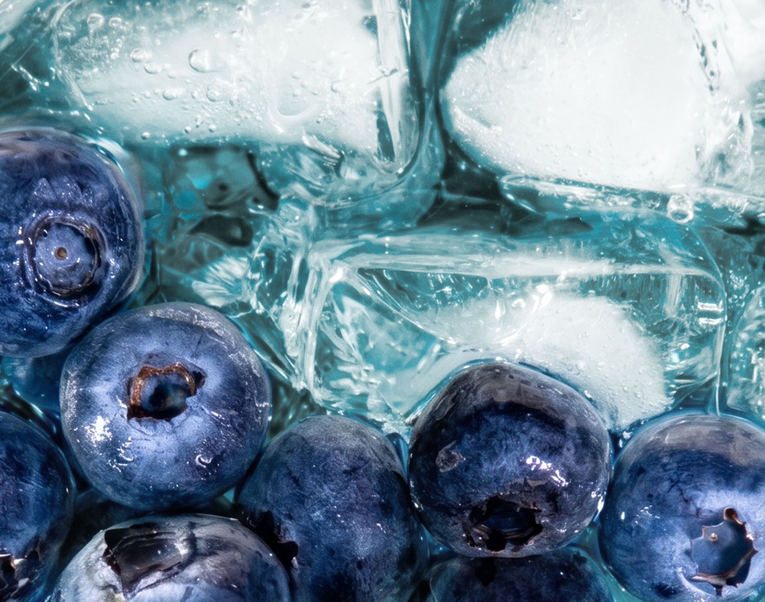 Blueberries surrounded by ice cubes on a blue background.