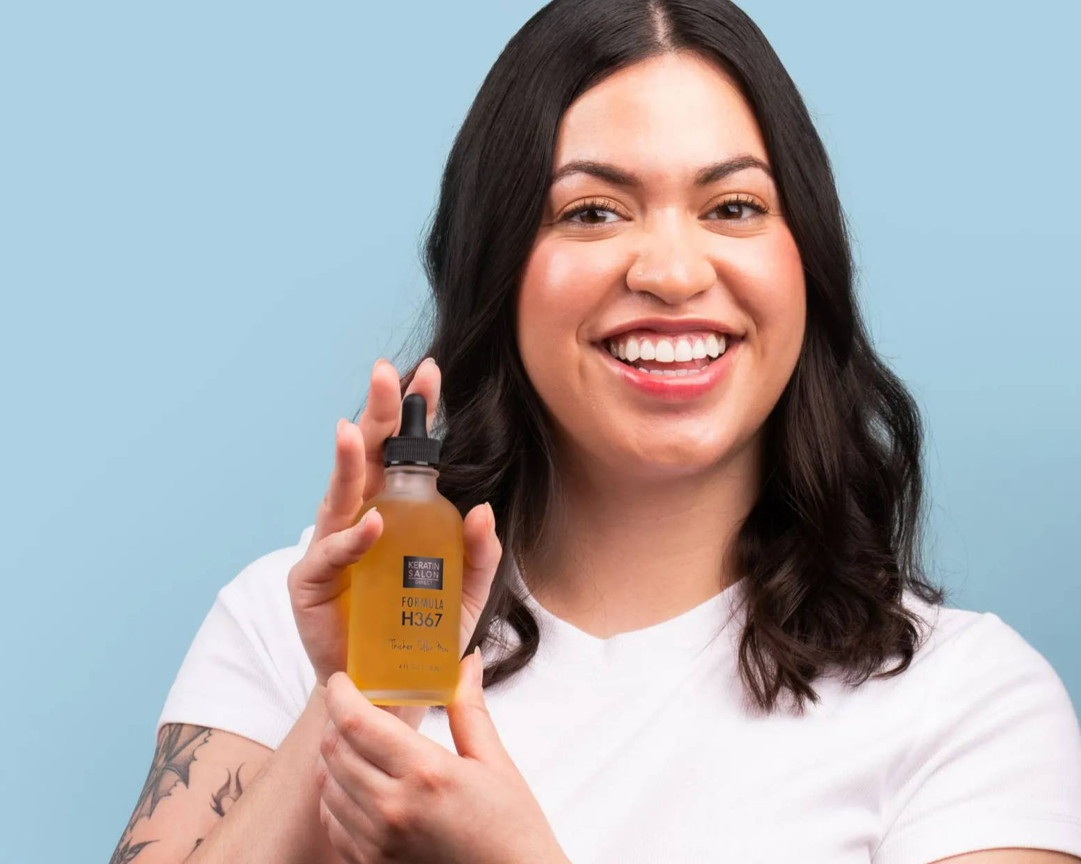 woman with hair growth product in hand