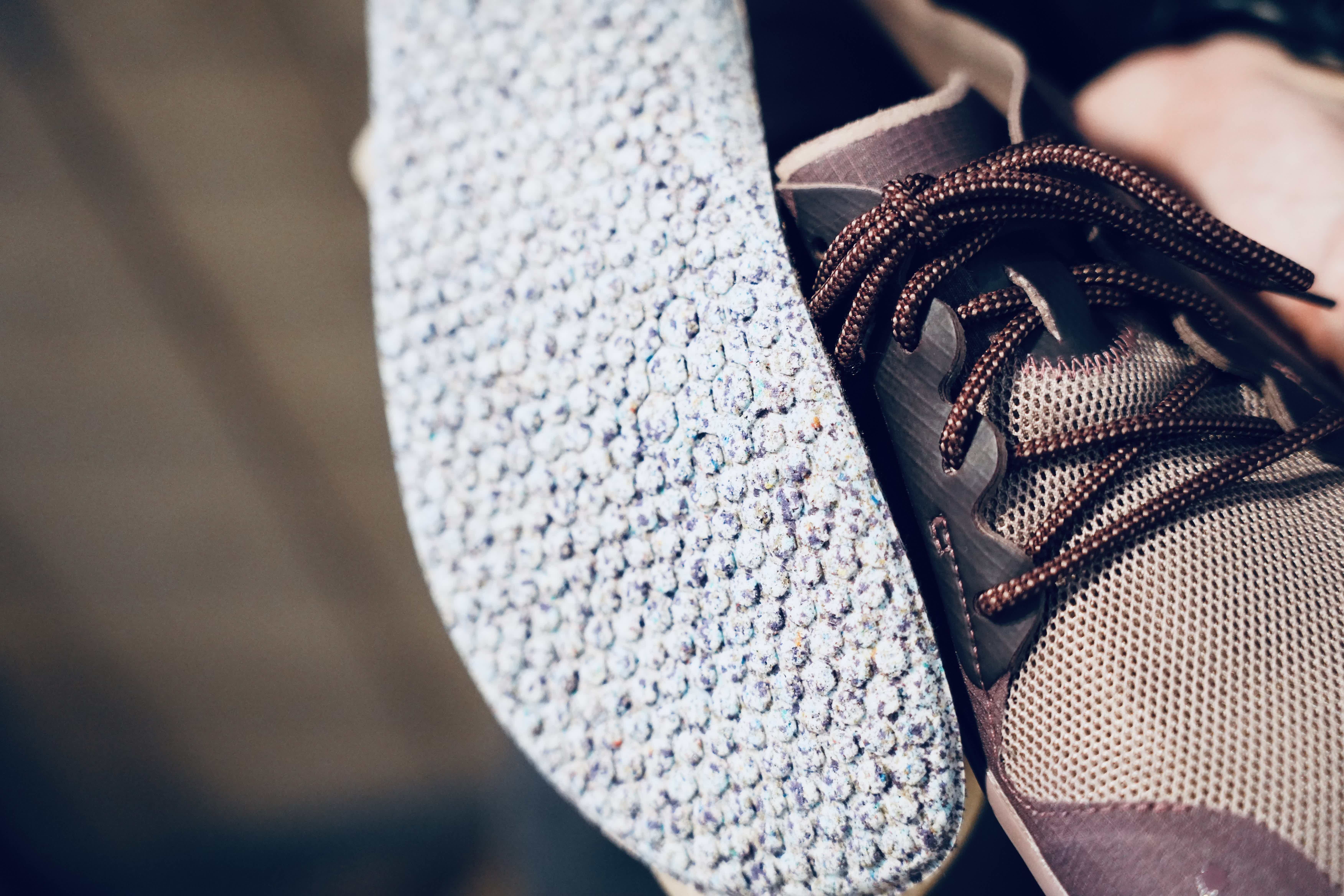 Close-up of a sneaker showing laces and textured sole.